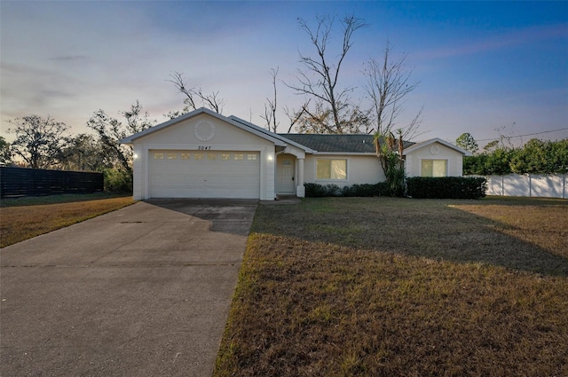 ranch-style home featuring a garage and a yard