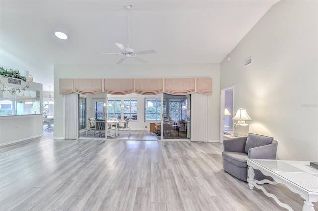 living room featuring ceiling fan, lofted ceiling, and light hardwood / wood-style floors