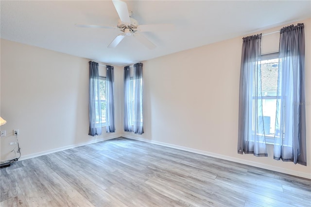 empty room with ceiling fan, a healthy amount of sunlight, and light hardwood / wood-style floors