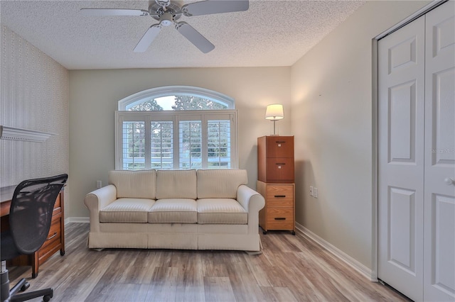 office with ceiling fan, light wood-type flooring, and a textured ceiling