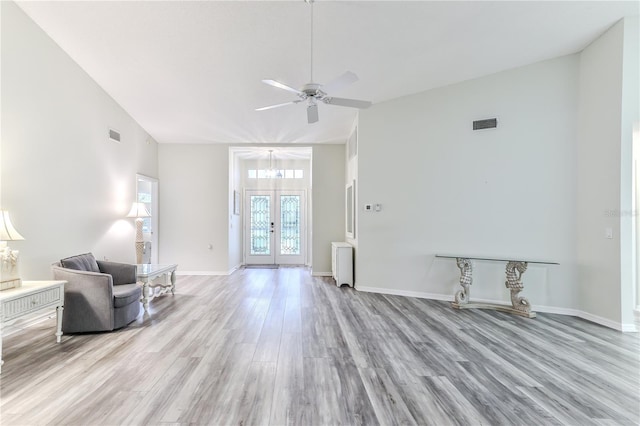 interior space featuring radiator heating unit, lofted ceiling, french doors, light wood-type flooring, and ceiling fan