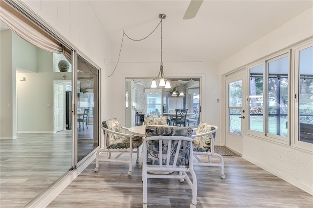 dining space with hardwood / wood-style floors and a notable chandelier