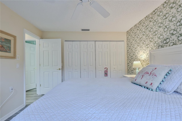 bedroom featuring ceiling fan, a closet, and a textured ceiling