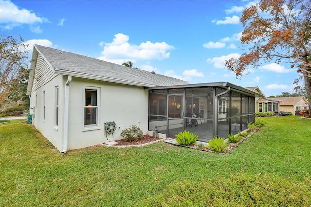 rear view of property featuring a patio area, a sunroom, and a yard