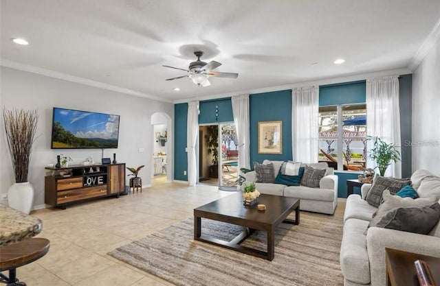 tiled living room with ornamental molding and ceiling fan