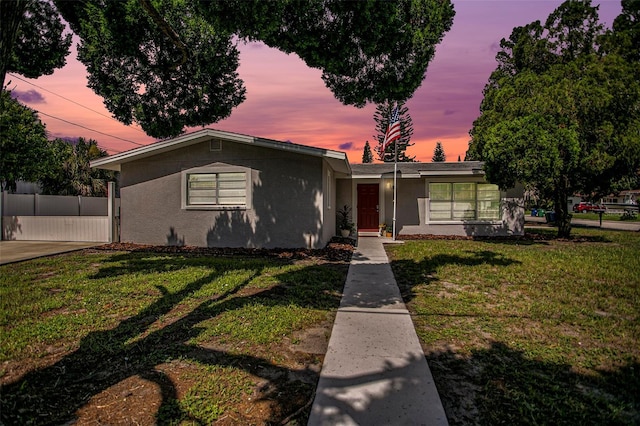 ranch-style home with a lawn