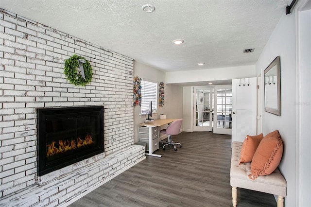 office area featuring a textured ceiling, dark hardwood / wood-style floors, french doors, and a fireplace