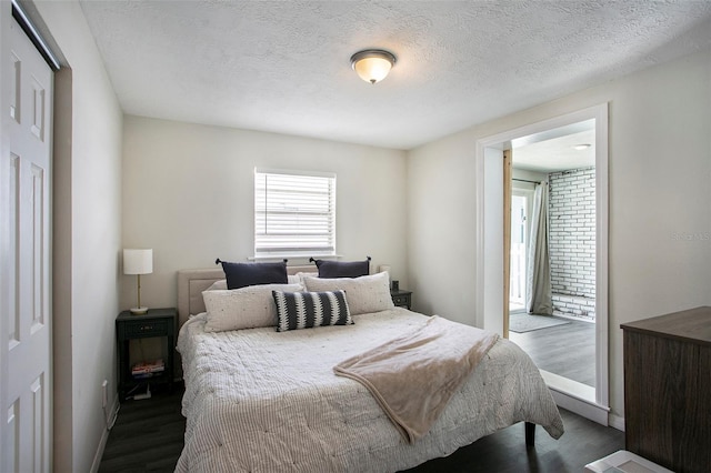 bedroom with a textured ceiling and dark wood-type flooring