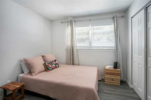 bedroom with a textured ceiling and dark hardwood / wood-style floors