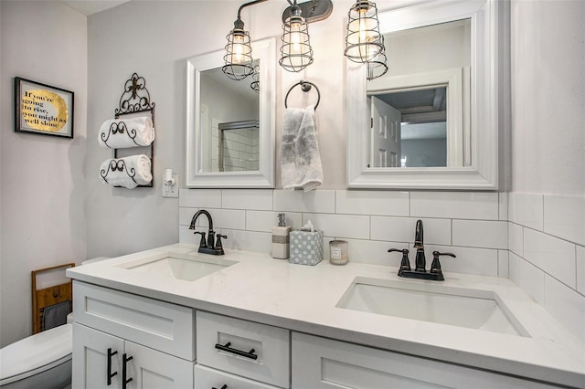 bathroom featuring toilet, vanity, and tasteful backsplash