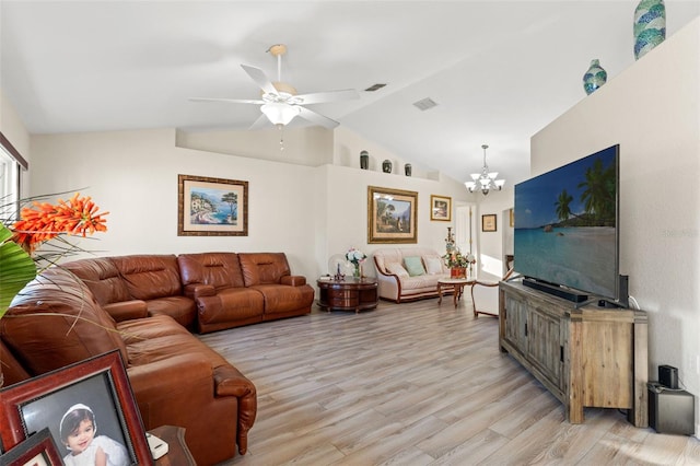 living room with ceiling fan with notable chandelier, light wood-type flooring, and vaulted ceiling