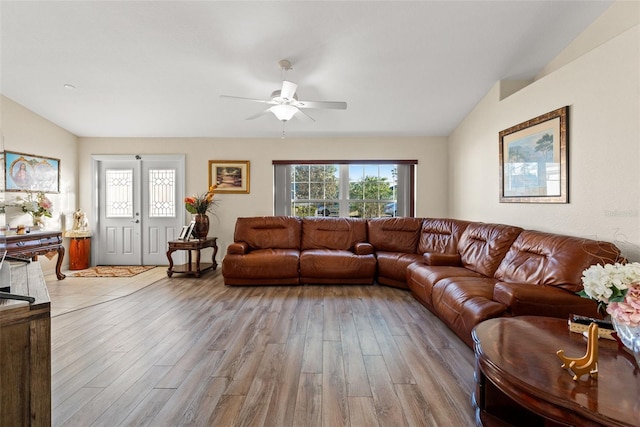 living room featuring lofted ceiling, ceiling fan, and light hardwood / wood-style floors