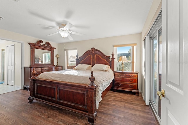 bedroom with dark hardwood / wood-style flooring, multiple windows, and ceiling fan