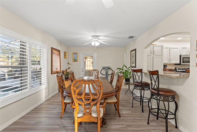 dining space featuring ceiling fan, light hardwood / wood-style flooring, and a healthy amount of sunlight