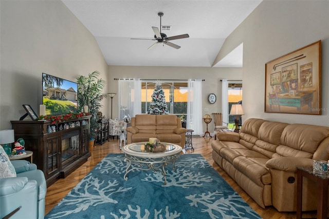 living room featuring ceiling fan, vaulted ceiling, and light wood-type flooring