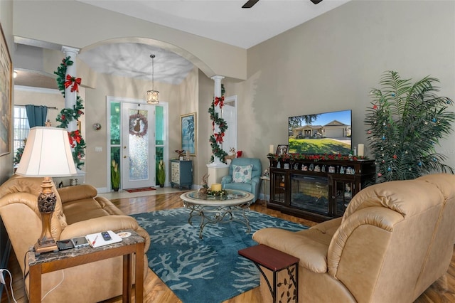 living room featuring ceiling fan, light hardwood / wood-style floors, and decorative columns