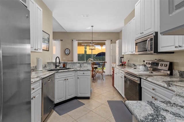 kitchen featuring sink, white cabinetry, appliances with stainless steel finishes, and hanging light fixtures