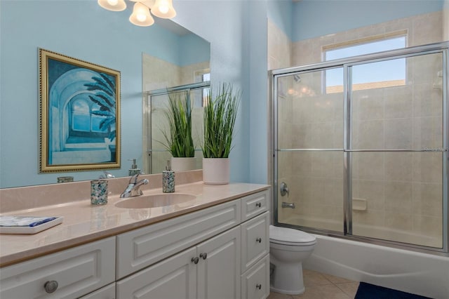 full bathroom featuring tile patterned floors, enclosed tub / shower combo, vanity, and toilet