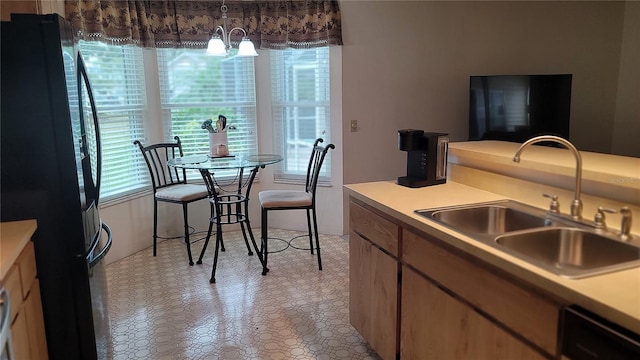 kitchen with sink, a chandelier, black appliances, and a healthy amount of sunlight