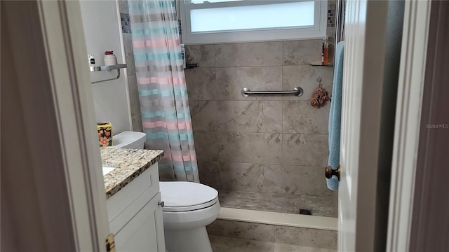 bathroom featuring toilet, vanity, and a shower with curtain