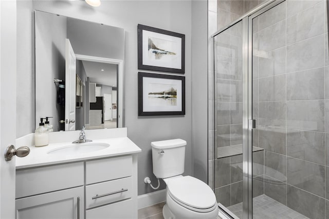 bathroom with an enclosed shower, vanity, and toilet