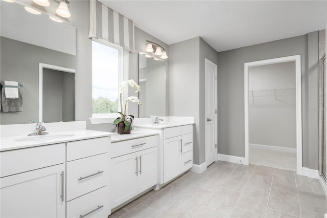 bathroom with a shower with door, tile patterned floors, and vanity