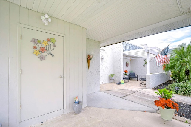 entrance to property featuring a patio area and a pergola