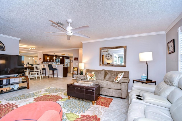 living room featuring a textured ceiling, ceiling fan, and crown molding