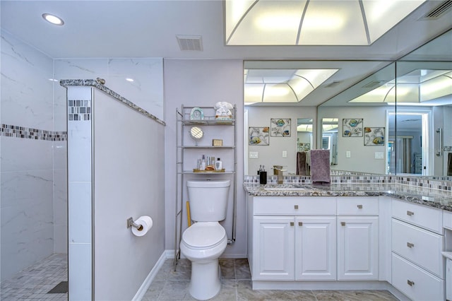 bathroom featuring tiled shower, vanity, and toilet