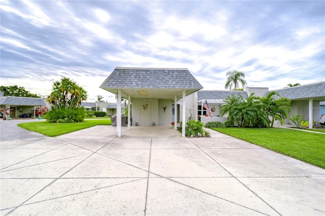 view of front facade with a carport and a front lawn