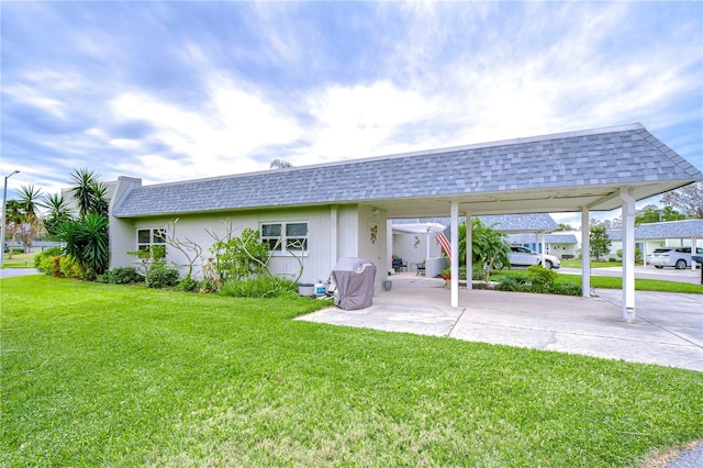 rear view of house with a yard and a carport