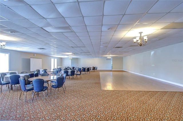 dining room featuring a chandelier, a drop ceiling, and a wealth of natural light