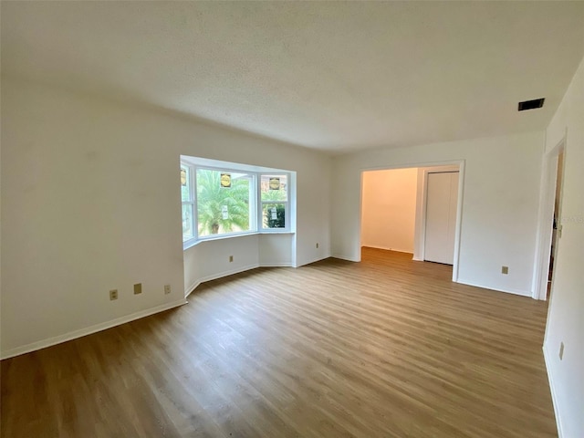 unfurnished room with wood-type flooring