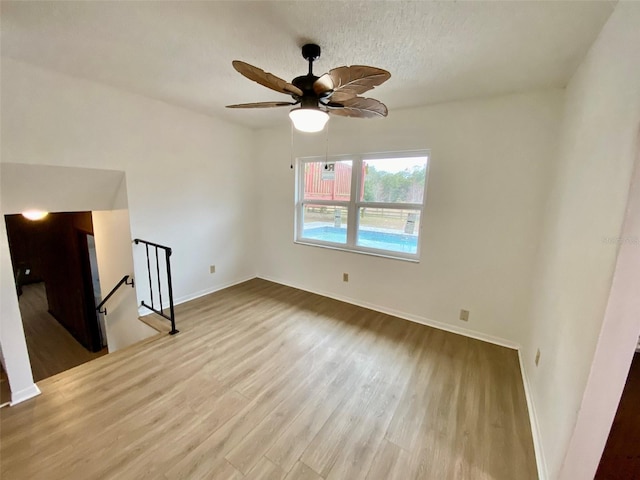 unfurnished living room with a textured ceiling, ceiling fan, and light hardwood / wood-style floors