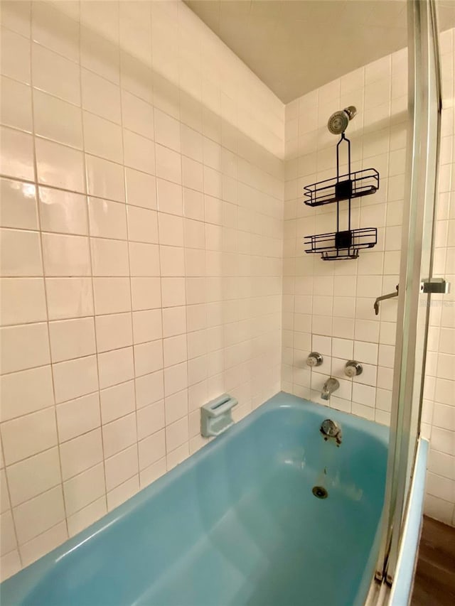 bathroom with a bathing tub and hardwood / wood-style flooring