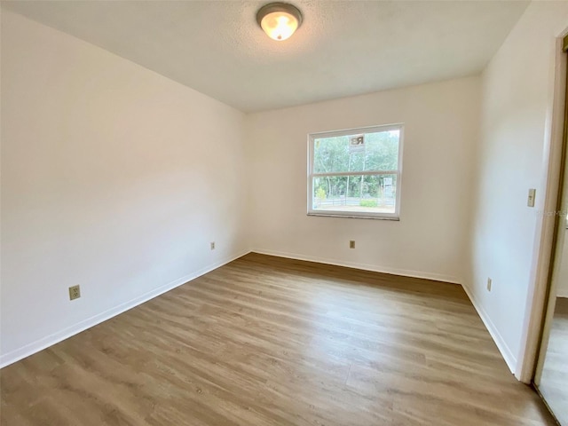 unfurnished room featuring a textured ceiling and wood-type flooring