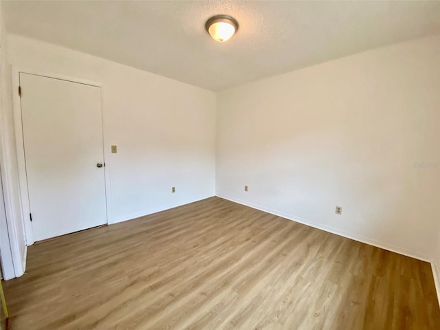 unfurnished room featuring a textured ceiling and hardwood / wood-style floors