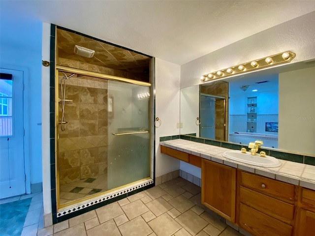 bathroom featuring tile patterned flooring, an enclosed shower, and vanity