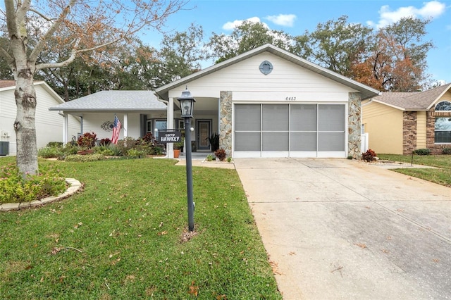 ranch-style house featuring covered porch, cooling unit, a front yard, and a garage