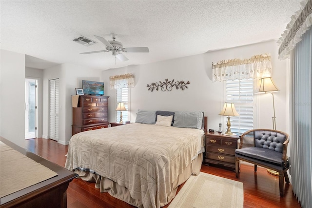 bedroom featuring ceiling fan, hardwood / wood-style floors, and a textured ceiling