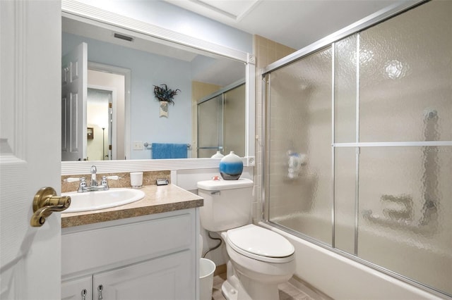 full bathroom featuring toilet, vanity, and shower / bath combination with glass door