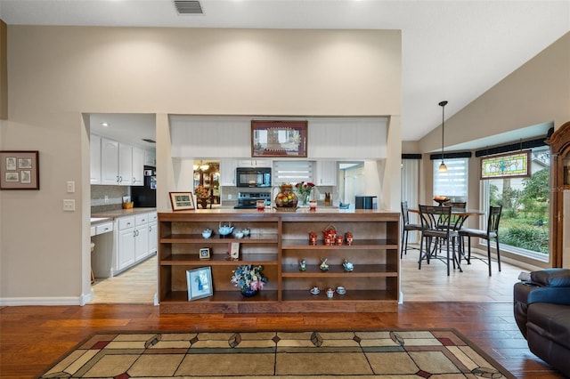 living room with vaulted ceiling and light hardwood / wood-style flooring