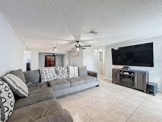 tiled living room with a textured ceiling and ceiling fan