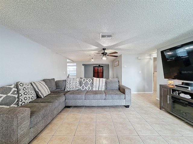 tiled living room featuring a textured ceiling and ceiling fan