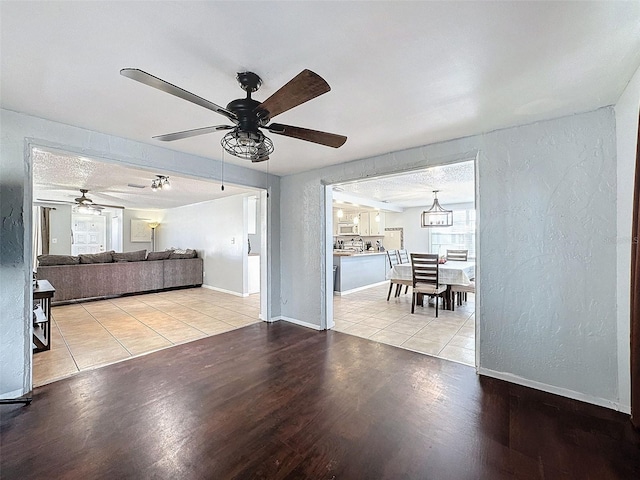 unfurnished living room featuring a textured ceiling and light wood-type flooring