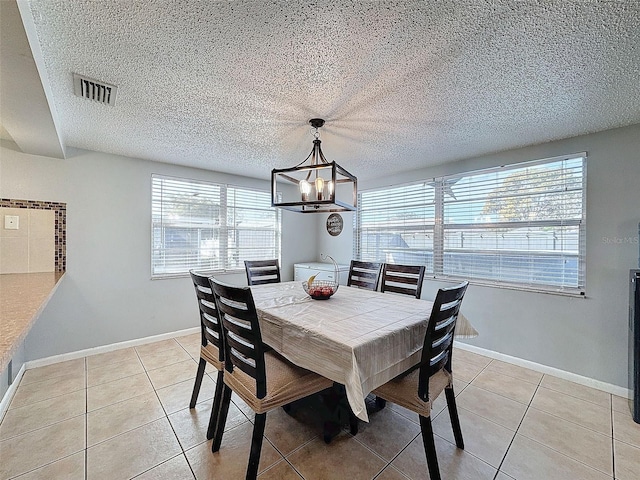 tiled dining space featuring a chandelier