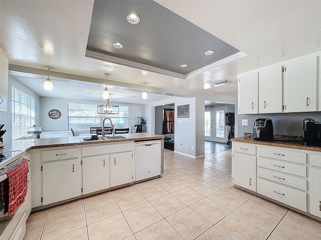 kitchen featuring decorative light fixtures, sink, a tray ceiling, and white appliances