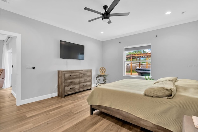 bedroom with crown molding, ceiling fan, and light hardwood / wood-style flooring