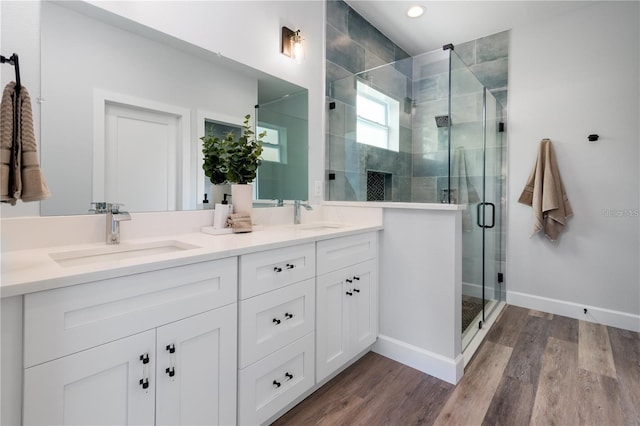 bathroom featuring an enclosed shower, wood-type flooring, and vanity