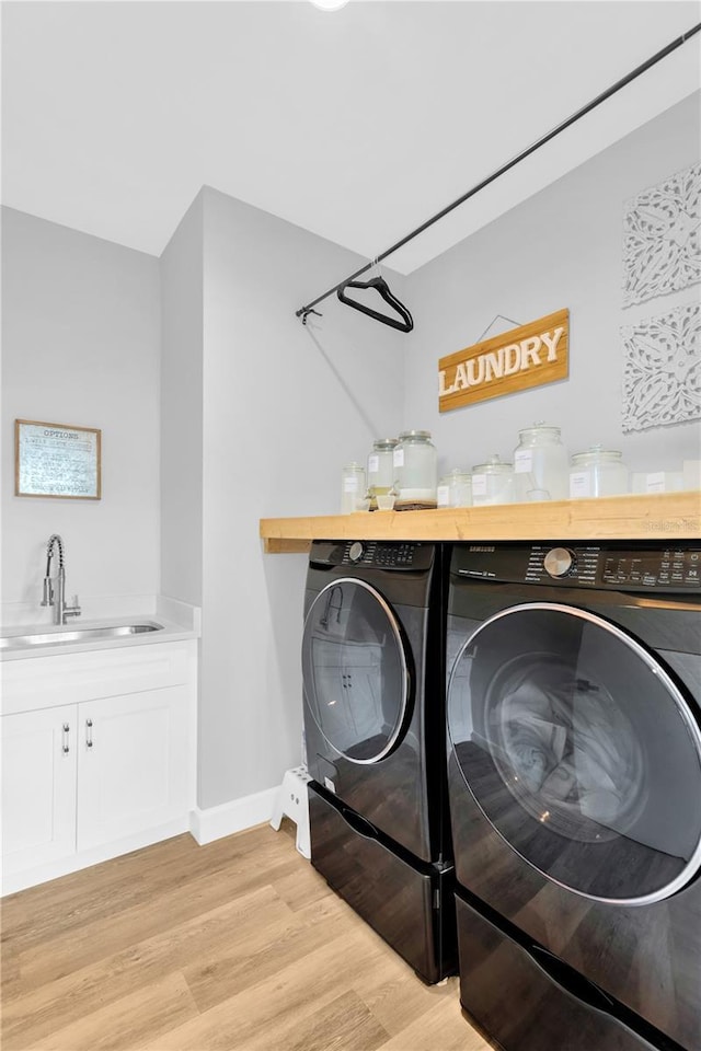 washroom featuring sink, washer and dryer, and light hardwood / wood-style floors